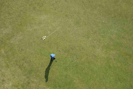 golfer putting on green short grass with flagstick out 