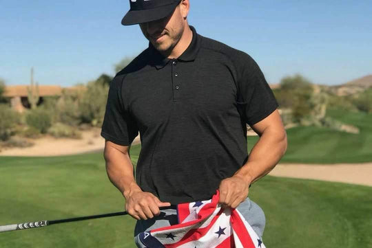 man wiping golf club with golf towel 